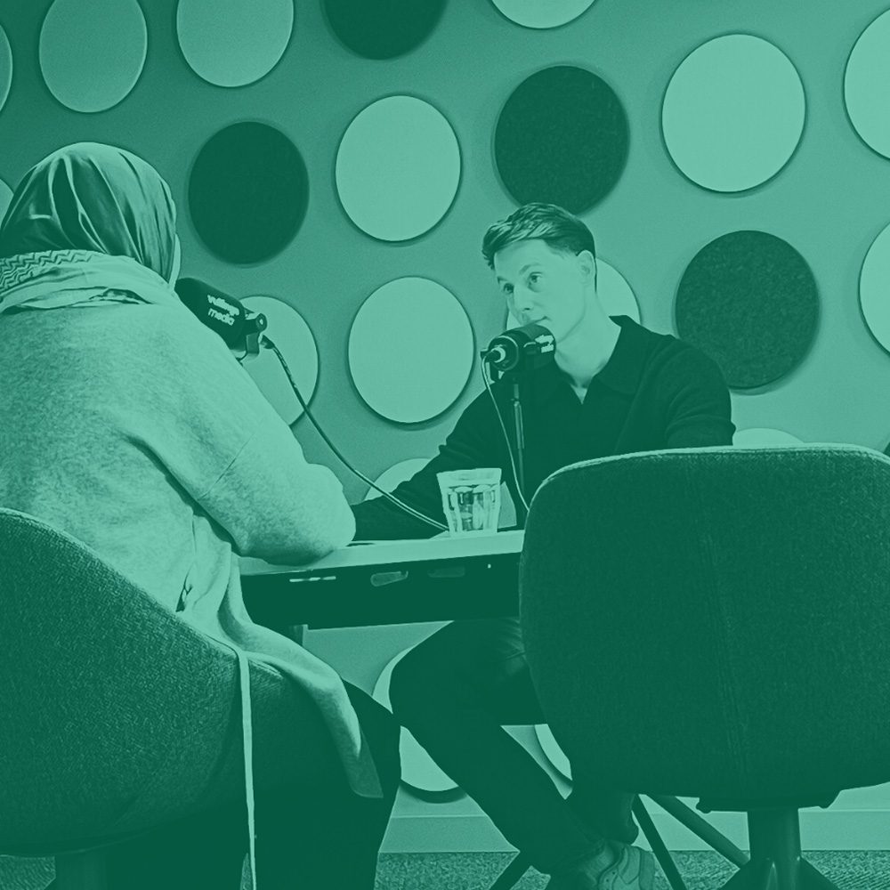 Opname van de Goede Bedoelingen Podcast: host Nathan van Groenigen in gesprek met een gast aan microfoons in de studio.