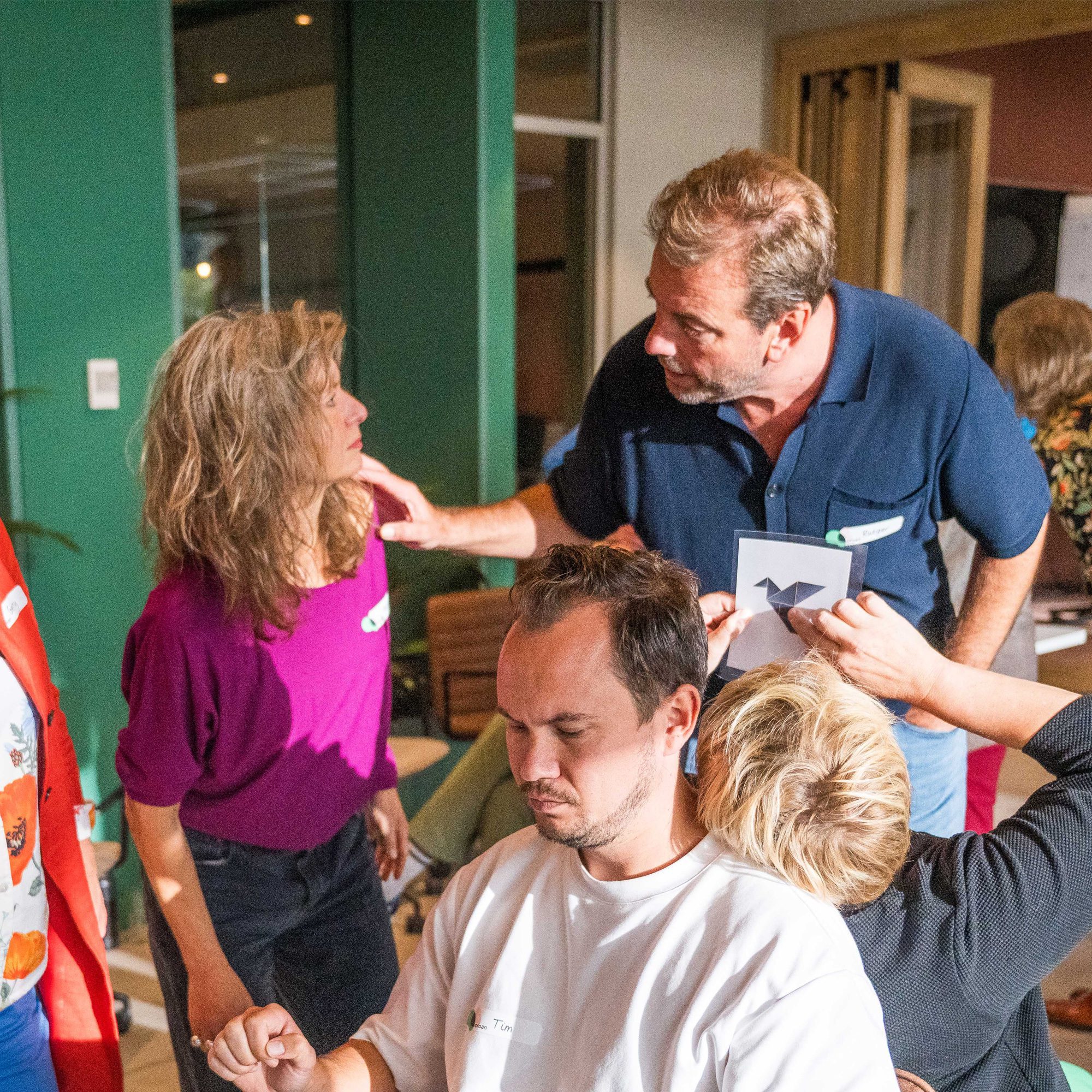 Collega bespreekt kritisch punt tijdens teamoverleg terwijl anderen luisteren